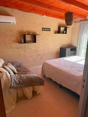 a bedroom with two beds and a bench in a room at Hermosa Casa en Mirador del Lago - Bialet Masse in Bialet Massé