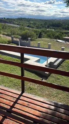 a wooden bench sitting on a fence with a swimming pool at Hermosa Casa en Mirador del Lago - Bialet Masse in Bialet Massé