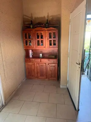 a kitchen with a wooden cabinet in a hallway at Hermosa Casa en Mirador del Lago - Bialet Masse in Bialet Massé