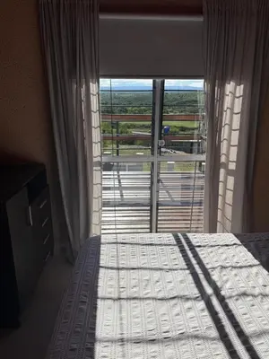 a bedroom with a bed and a large window at Hermosa Casa en Mirador del Lago - Bialet Masse in Bialet Massé