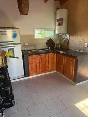 a kitchen with a white refrigerator and wooden cabinets at Hermosa Casa en Mirador del Lago - Bialet Masse in Bialet Massé