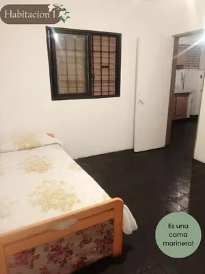 a bedroom with two beds and a window and a door at Departamento dos habitaciones en zona tranquila in Cordoba