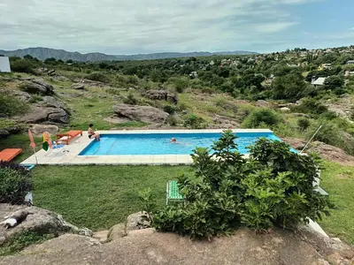 a swimming pool on a hill with people in it at Xaraba in Villa Parque Siquiman