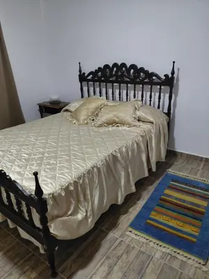 a bedroom with a large bed with a wooden headboard at Mi Destino in Tanti