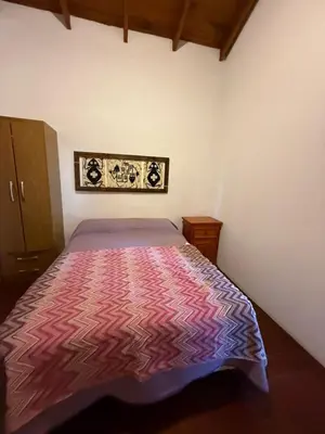 a bedroom with a bed with a colorful bedspread at Cabañas El Mirador in Alpa Corral