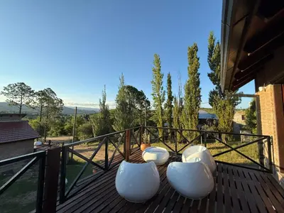 a deck with white chairs on top of a house at Cabañas El Mirador in Alpa Corral