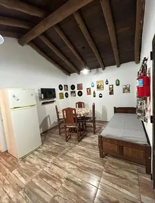 a living room with a refrigerator and a table at AlCarajo in Villa Yacanto