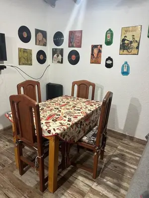 a dining room table with two chairs and a table with a patterned table at AlCarajo in Villa Yacanto