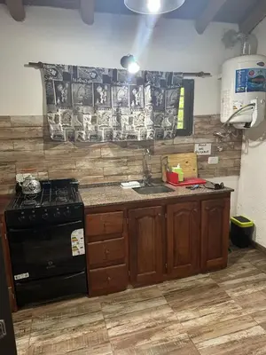 a kitchen with a stove and a sink in it at AlCarajo in Villa Yacanto