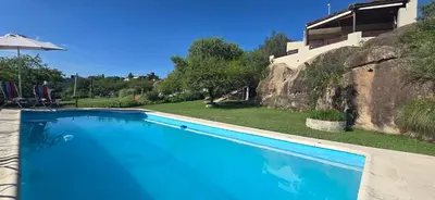 a large blue swimming pool in front of a house at El Mirador de la Finca in Cavalango
