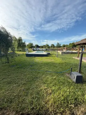 a large grass field with a volleyball court in the distance at Cabañas Marquetti 2 in Potrero de Garay
