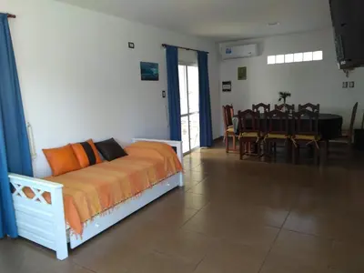 a bedroom with a bed and a dining room with a table at El Campito in San Antonio de Arredondo