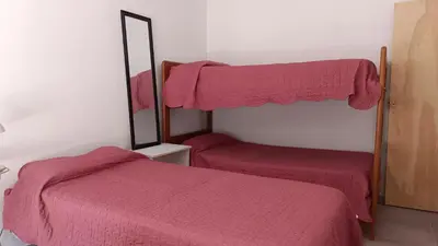 a bedroom with two beds with pink sheets and a mirror at La Casita de Daniel in San Antonio de Arredondo