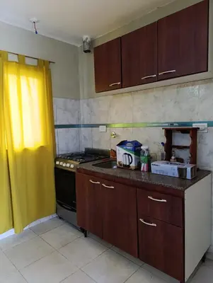 a kitchen with wooden cabinets and a stove top oven at Solo empresas mensual in Pilar