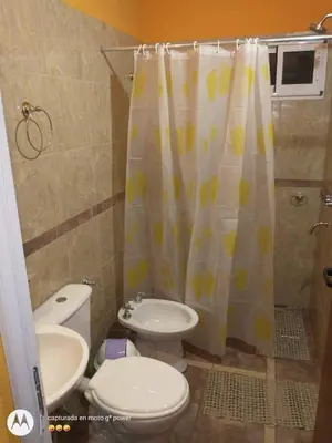 a bathroom with a toilet and a shower curtain at Nuestro sol-ar in Tanti