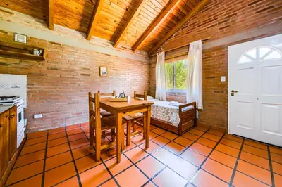 a kitchen with a wooden table and a white door at El Encuentro Casa de Campo in Río Cuarto
