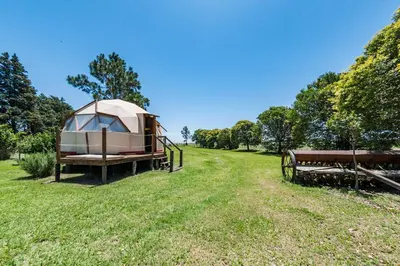 a tent in a field next to a bench at El Encuentro Casa de Campo in Río Cuarto