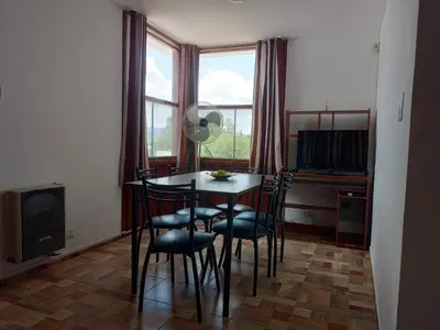 a dining room with a table and chairs and a television at Luminoso in Villa Carlos Paz