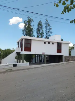 a white building with red windows on a street at Luminoso in Villa Carlos Paz