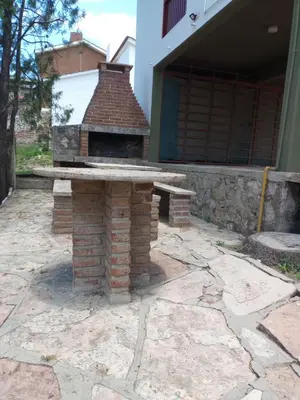 a brick oven sitting on a patio with a bench at Luminoso in Villa Carlos Paz