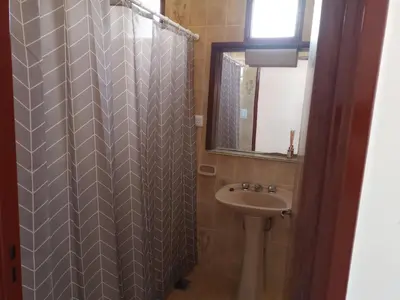 a bathroom with a shower curtain and a sink at Luminoso in Villa Carlos Paz