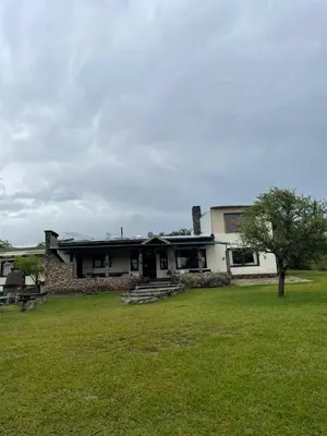 a house with a tree in front of a yard at La Vision, Casa de campo in Villa Quillinzo