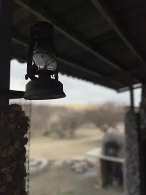 a black bell hanging from a building with a view at La Vision, Casa de campo in Villa Quillinzo
