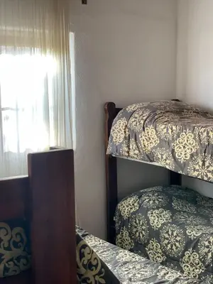 a bedroom with two bunk beds and a window at La Vision, Casa de campo in Villa Quillinzo