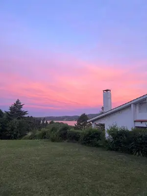 a sunset over a house with a grass yard at Mar y Mar in La Estancia