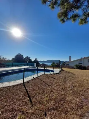 a fence around a swimming pool in a field at Mar y Mar in La Estancia