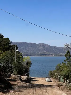 a car parked on a dirt road next to a body of water at Mar y Mar in La Estancia