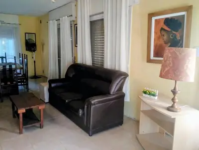 a living room with a leather couch and a table at Emilia Casa de Campo in Santa Rosa de Calamuchita