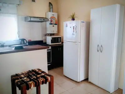 a kitchen with white appliances and a white refrigerator at Emilia Casa de Campo in Santa Rosa de Calamuchita