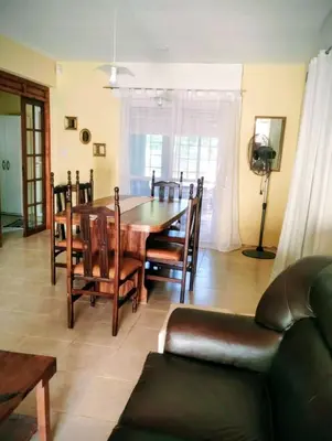a living room with a table and chairs and a couch at Emilia Casa de Campo in Santa Rosa de Calamuchita