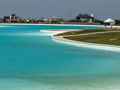 a body of blue water with buildings in the background at HOUSE SOUTH en AQUAVISTA VILLA RESIDENCIAL in Malagueño