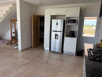 a kitchen with a refrigerator and a cat in a room at HOUSE SOUTH en AQUAVISTA VILLA RESIDENCIAL in Malagueño