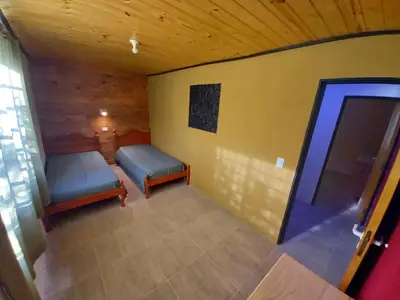 an empty room with two beds and a window at Casita los ceibos in Villa Santa Cruz del Lago