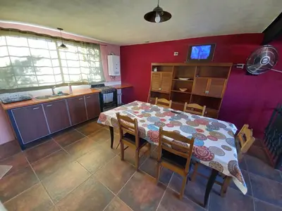 a kitchen and dining room with a table and chairs at Casita los ceibos in Villa Santa Cruz del Lago
