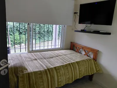 a bedroom with a bed and a flat screen tv at La tranquera ll in Trapiche