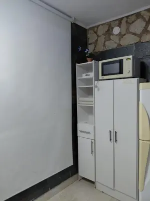 a small kitchen with a microwave on top of a refrigerator at La tranquera ll in Trapiche