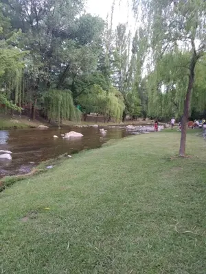 a river in a park next to a grass field at La tranquera ll in Trapiche