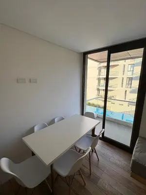 a white table and chairs in a room with a window at Departamento en Villa Carlos Paz in Villa Carlos Paz