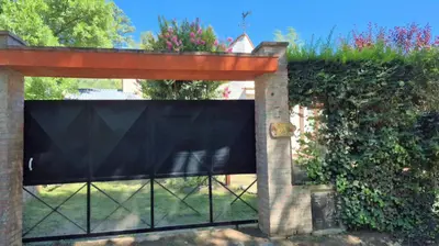 a black fence with a gate in a yard at Departamento tranquilo cerca de la terminal Villa General Belgrano a 5 cuadras del centro in Villa General Belgrano