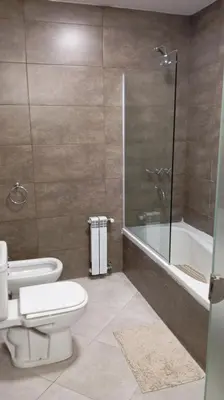 a bathroom with a shower and a toilet and a tub at Dpto Premium Costanera cochera y patio privado in Villa Carlos Paz