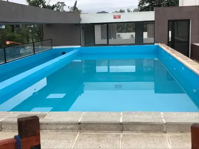 a large swimming pool with blue water at Dpto Premium Costanera cochera y patio privado in Villa Carlos Paz