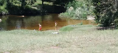two people standing in the water near a river at Los árboles in Cordoba