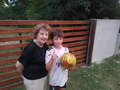 a woman and a young boy holding a soccer ball at Los árboles in Cordoba