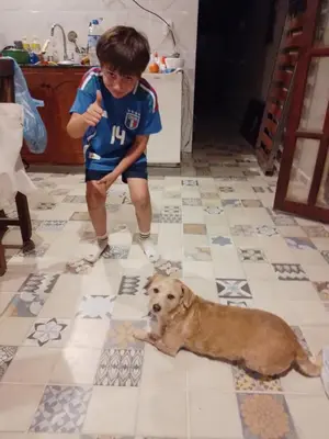 a young boy standing next to a dog on a tile floor at Los árboles in Cordoba