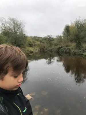 a young boy is looking at a river at Los árboles in Cordoba