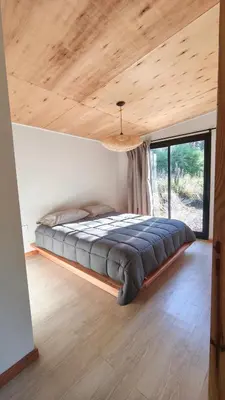 a large bed in a room with a large window at Aire in La Estancia